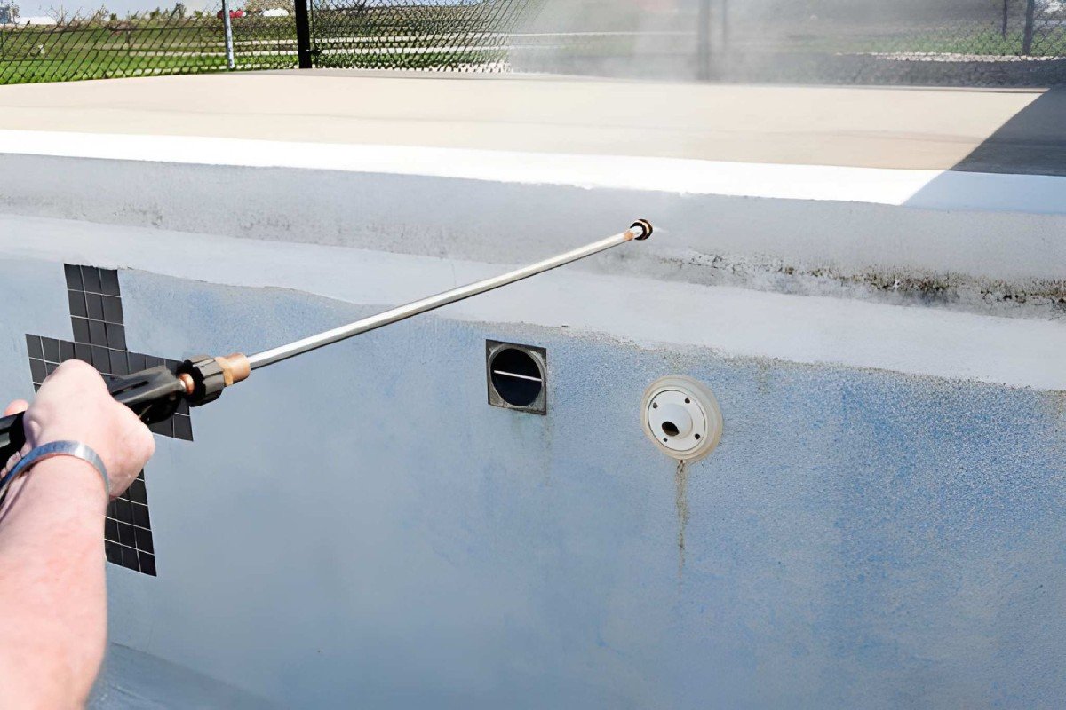 Pressure washing algae from a pool surrounding